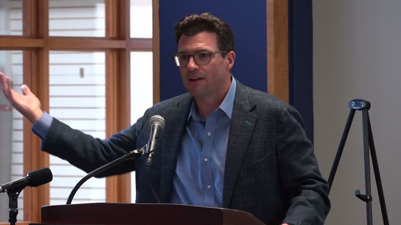 Dave Gillespie of AvalonBay Communities at the podium during the August 12, 2024 community meeting on the Salem State South Campus redevelopment, gesturing with his right hand mid-sentence.